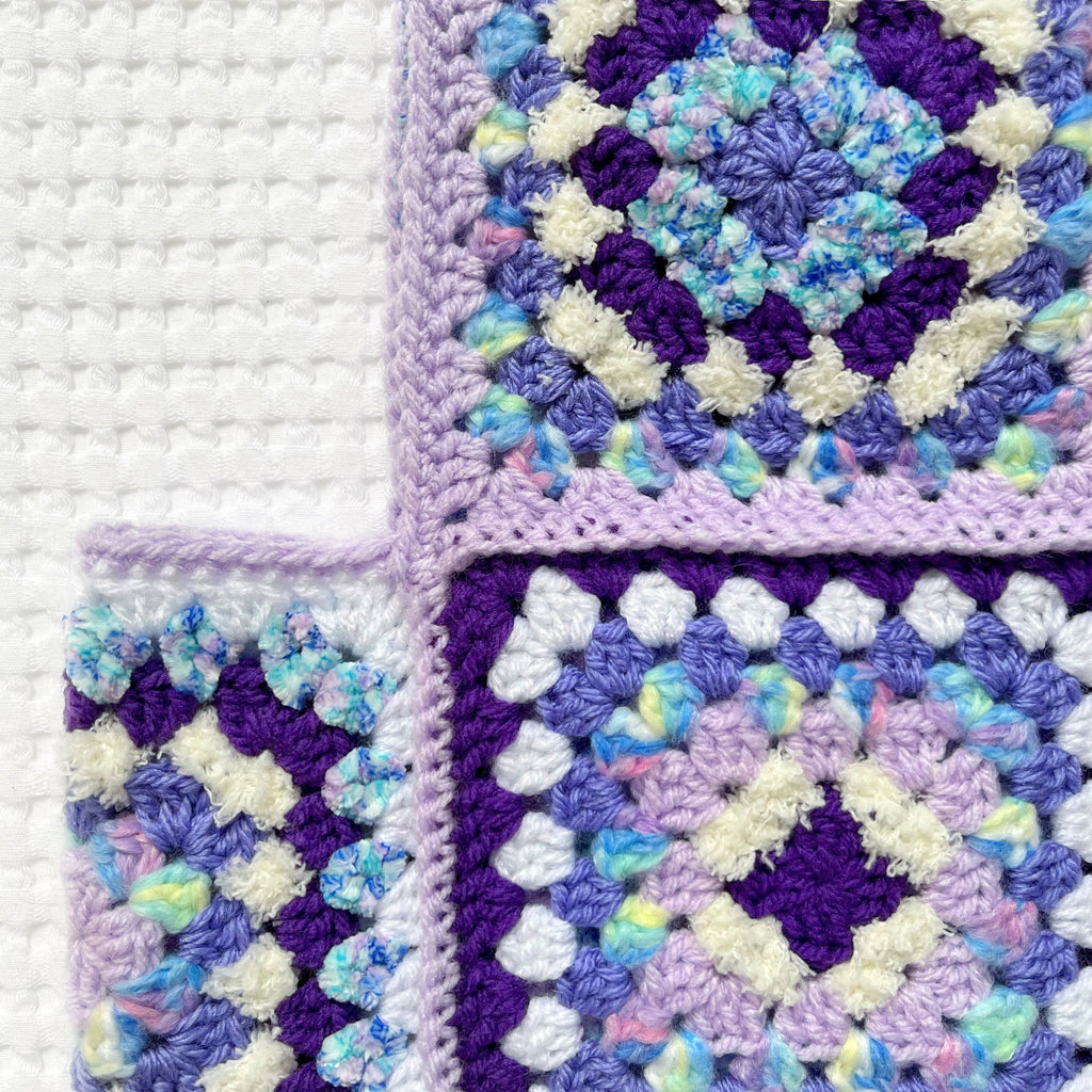 Colorful crocheted granny square balaclava on a white background