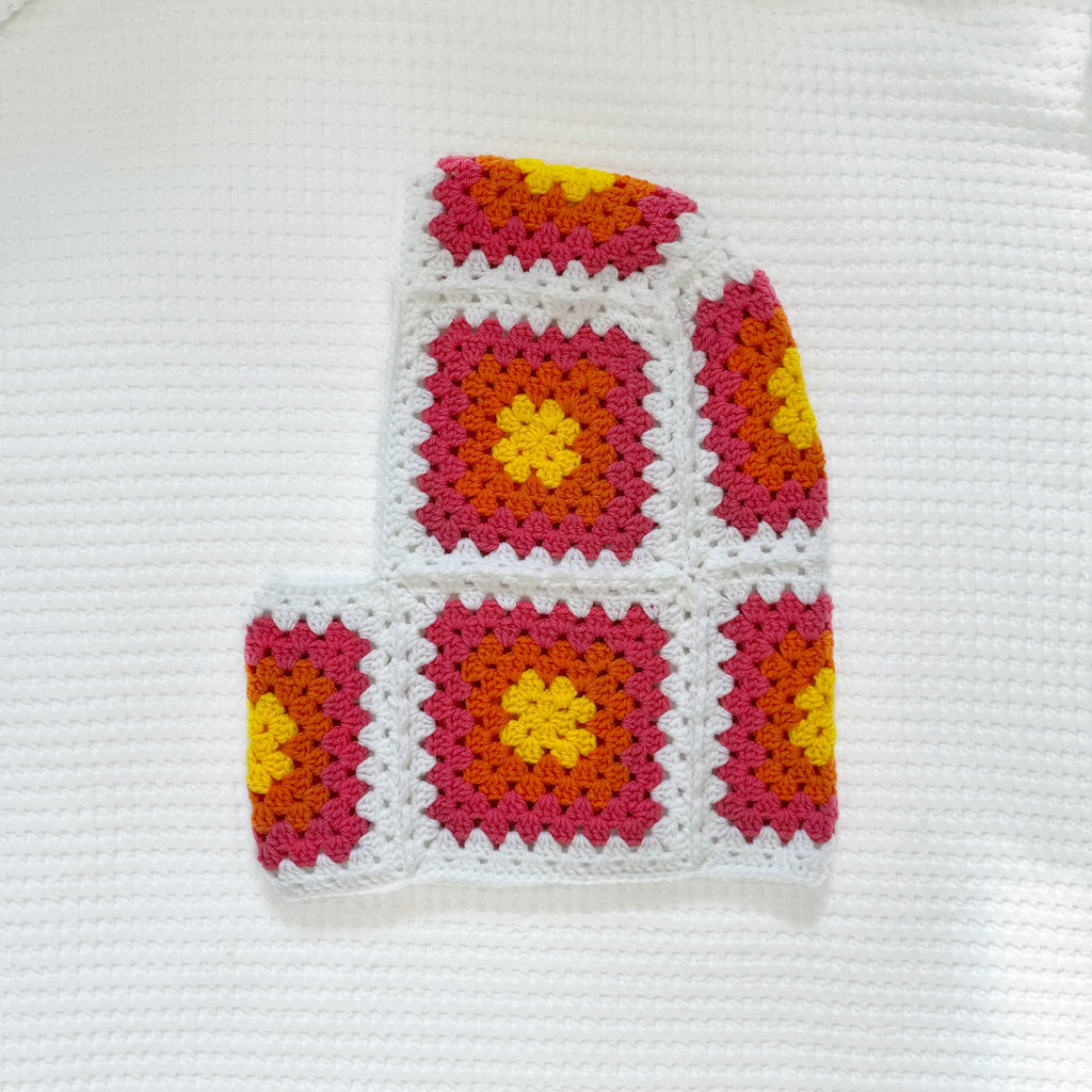 Colorful crocheted balaclava on a white background