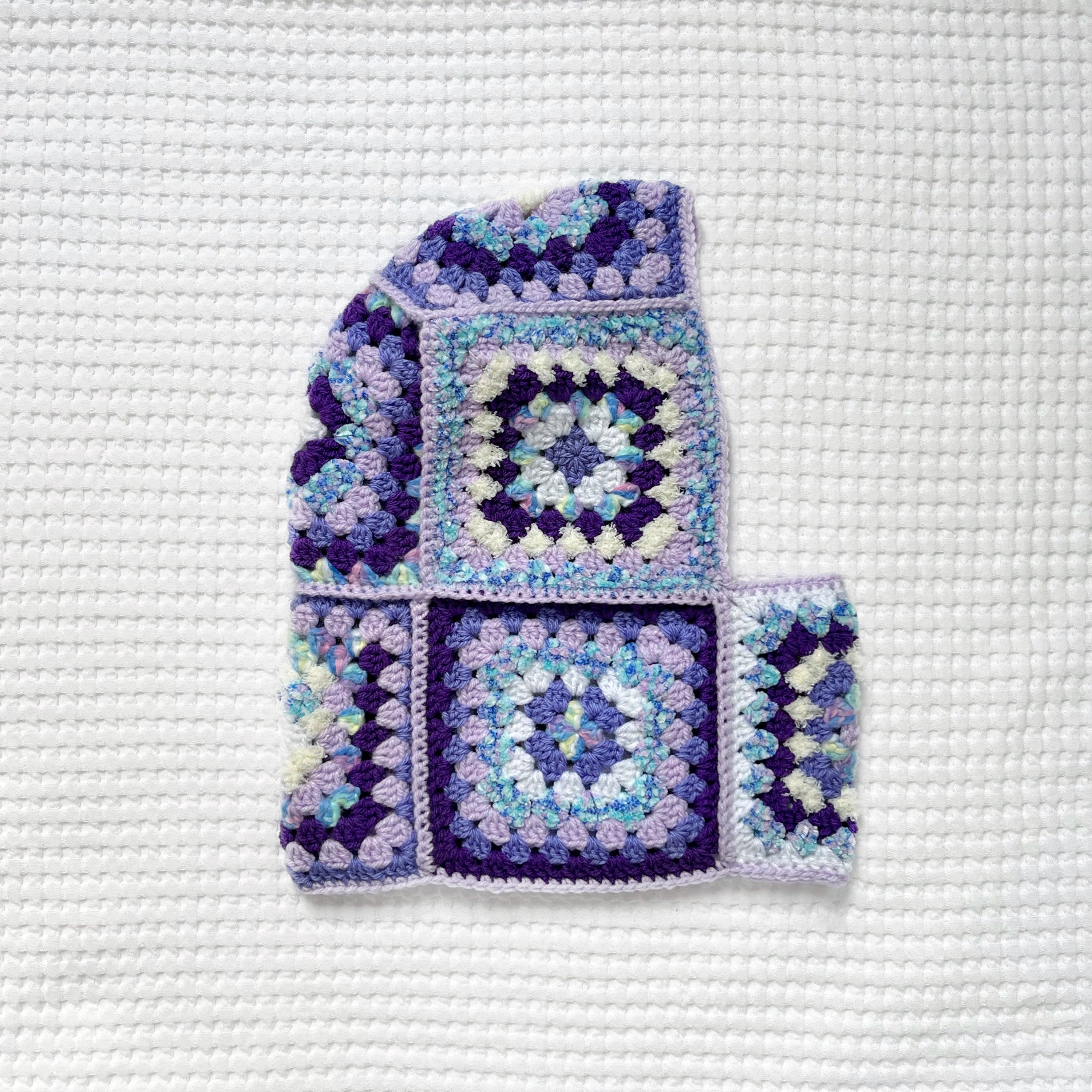 Crocheted balaclava on a textured white background