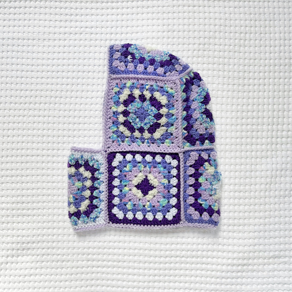 Crocheted balaclava on a textured white background