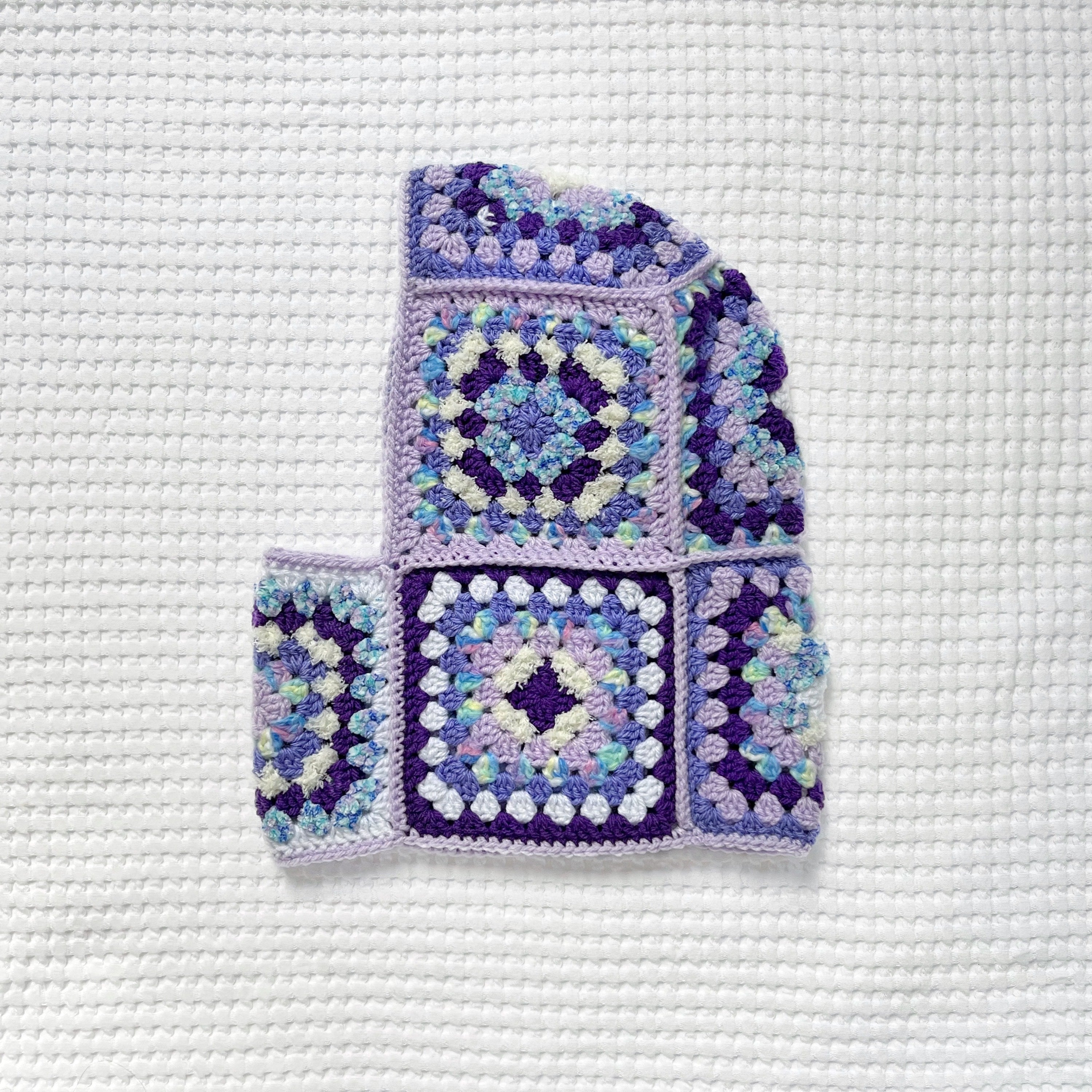 Crocheted balaclava on a textured white background