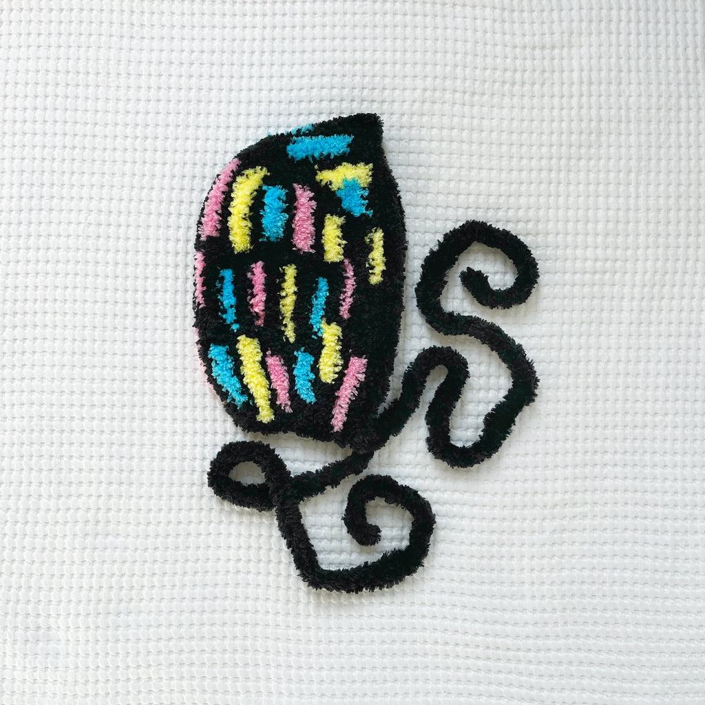 Crochet design of a colorful bonnet on white fabric