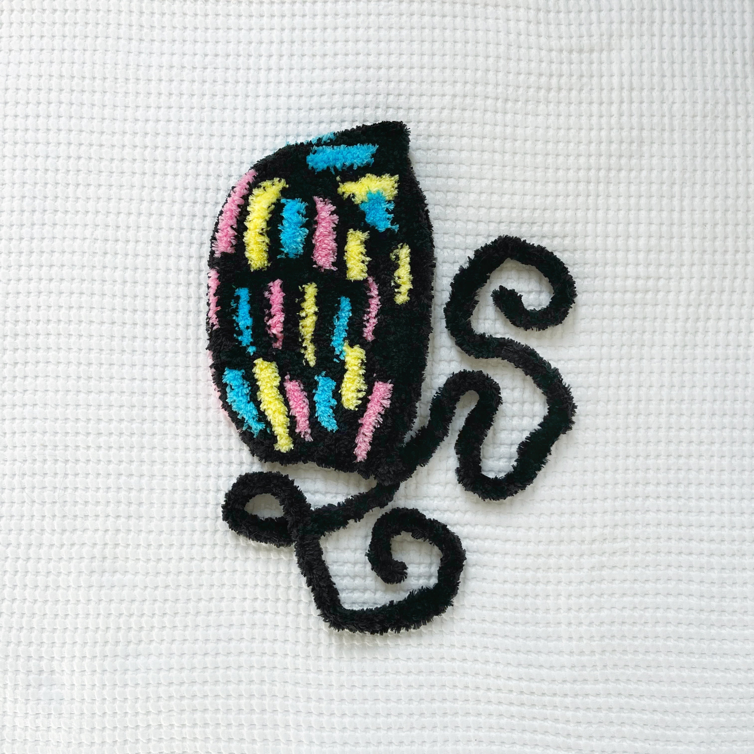 Crochet design of a colorful bonnet on white fabric