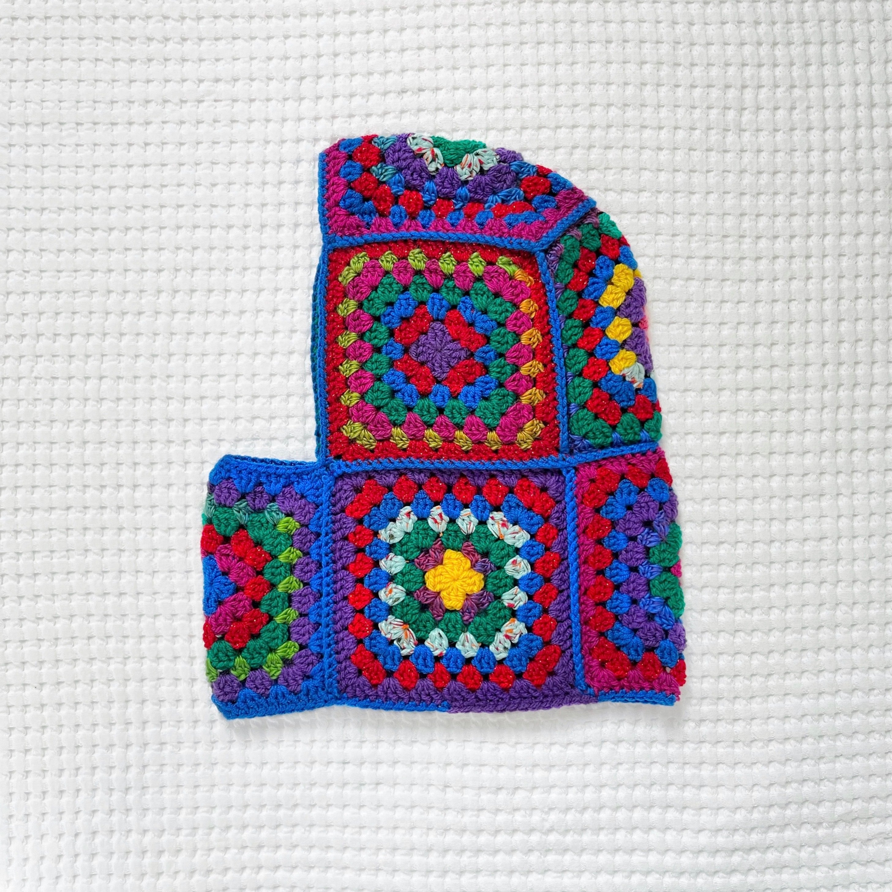 Colorful crocheted balaclava with a geometric pattern on a white background