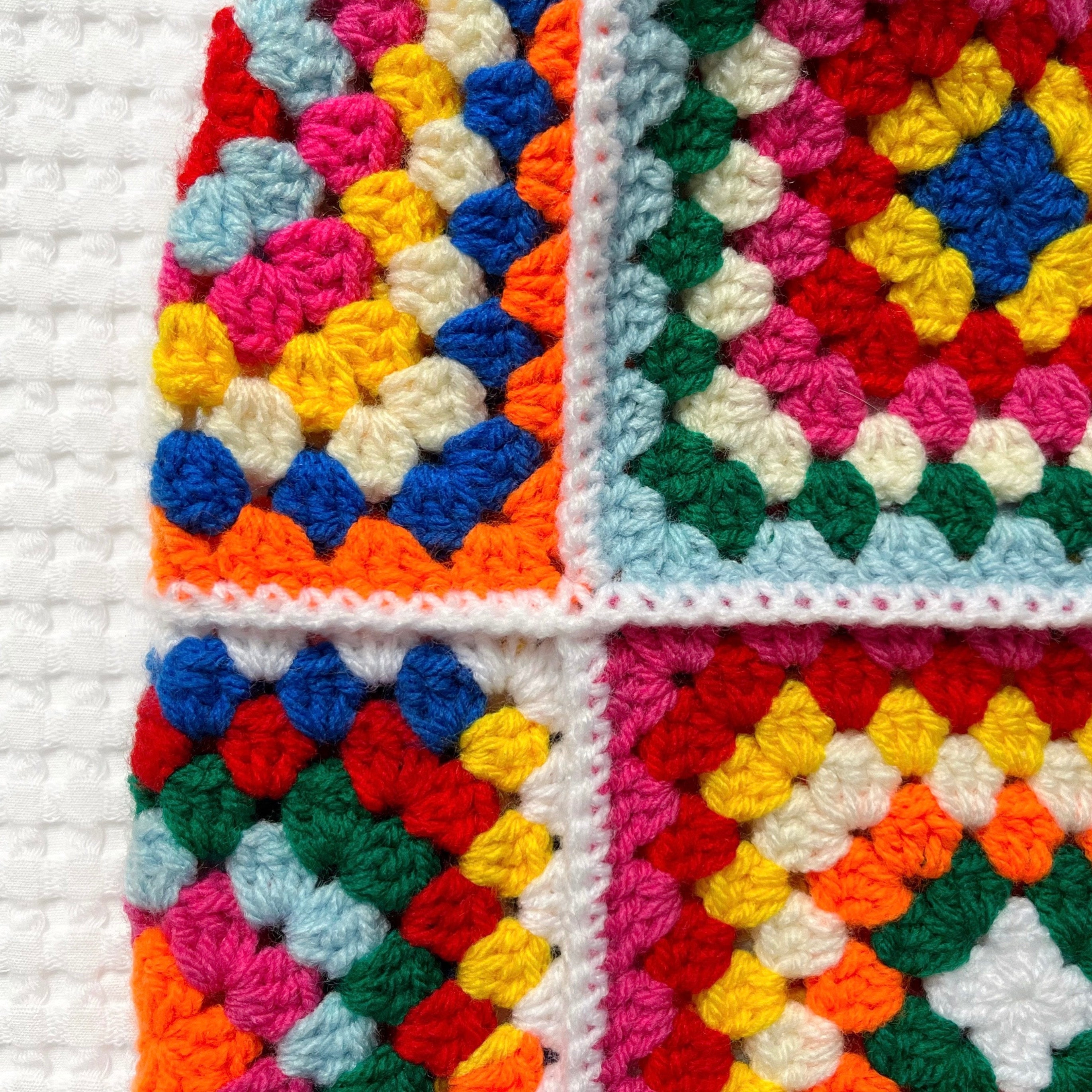 Colorful crocheted balaclava on a white background.