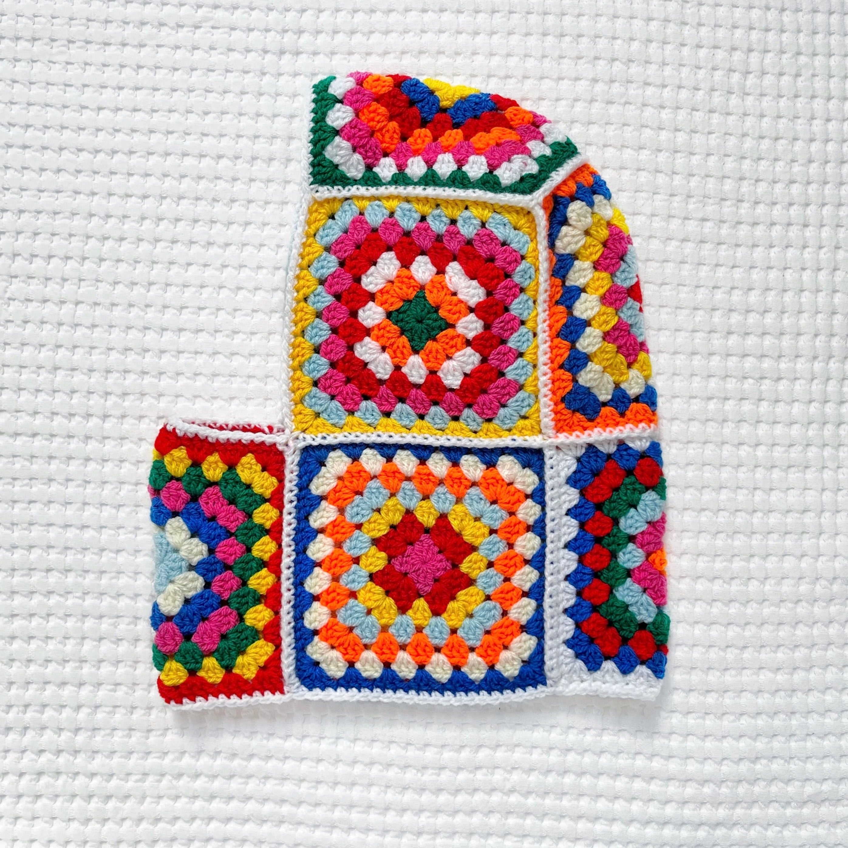 Colorful crocheted balaclava on a white background