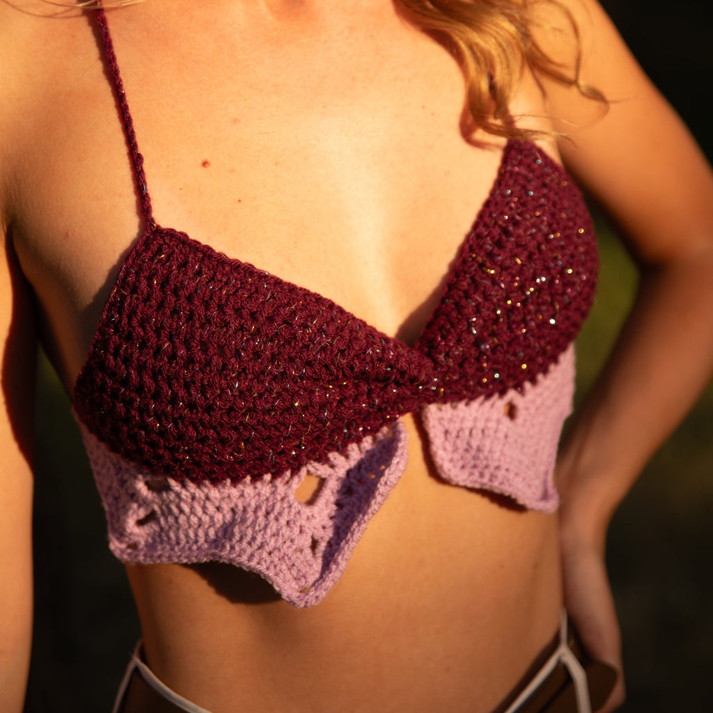 Person wearing a crochet bikini top with a blurred background