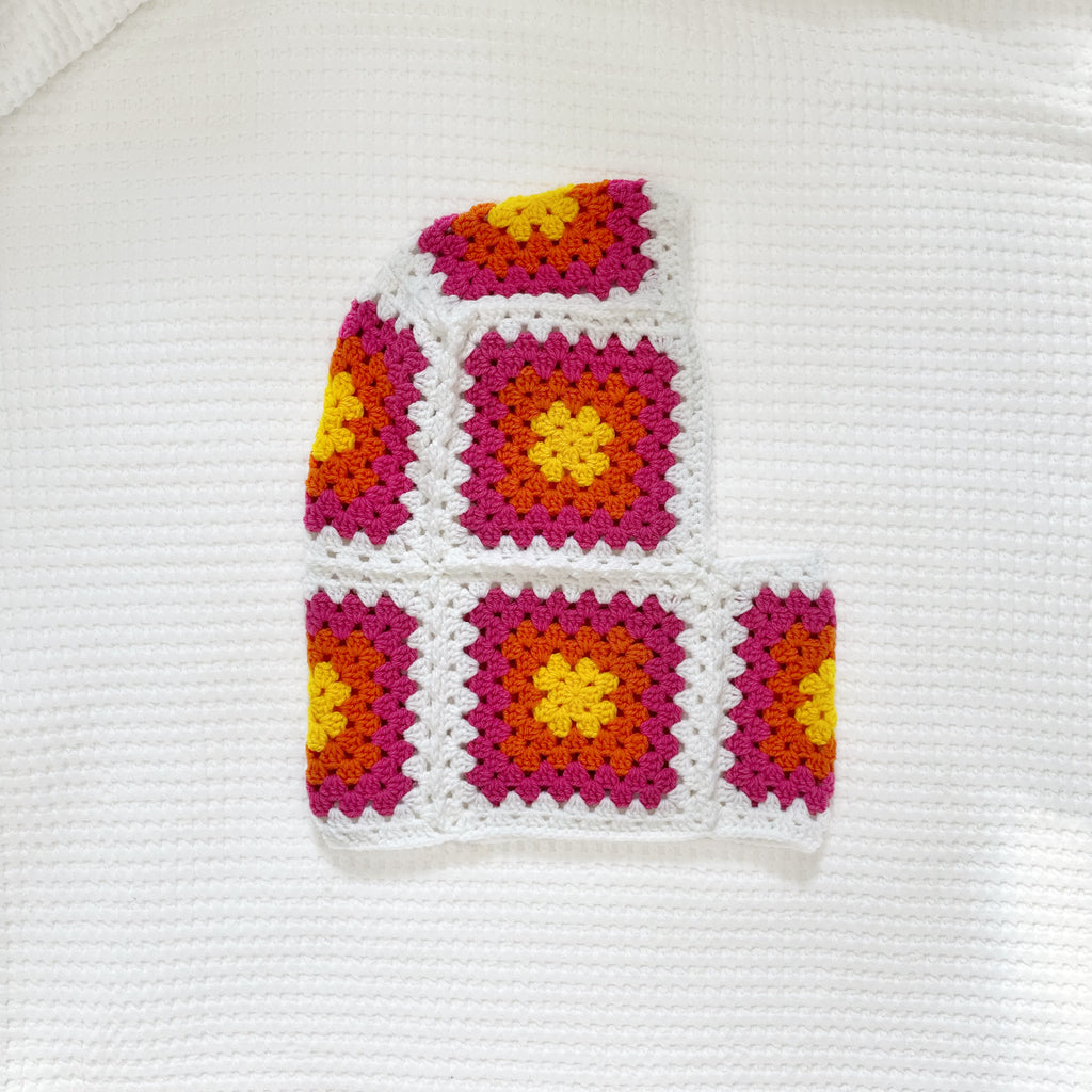 Colorful crocheted balaclava on a white background