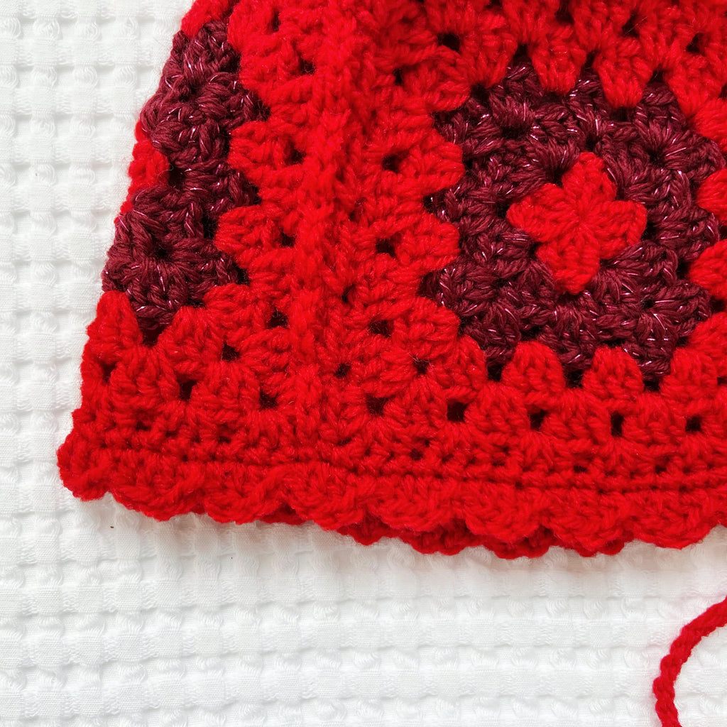 Red crochet bonnet on a white background