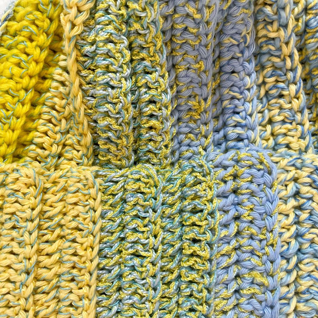 Close-up of a crochet beanie with yellow and blue patterns