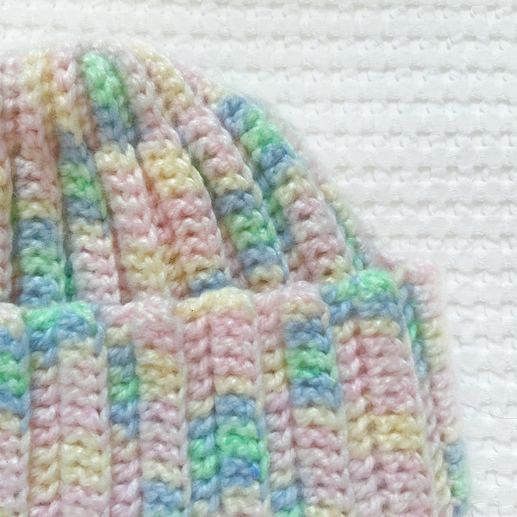Pastel striped crochet beanie on a white background