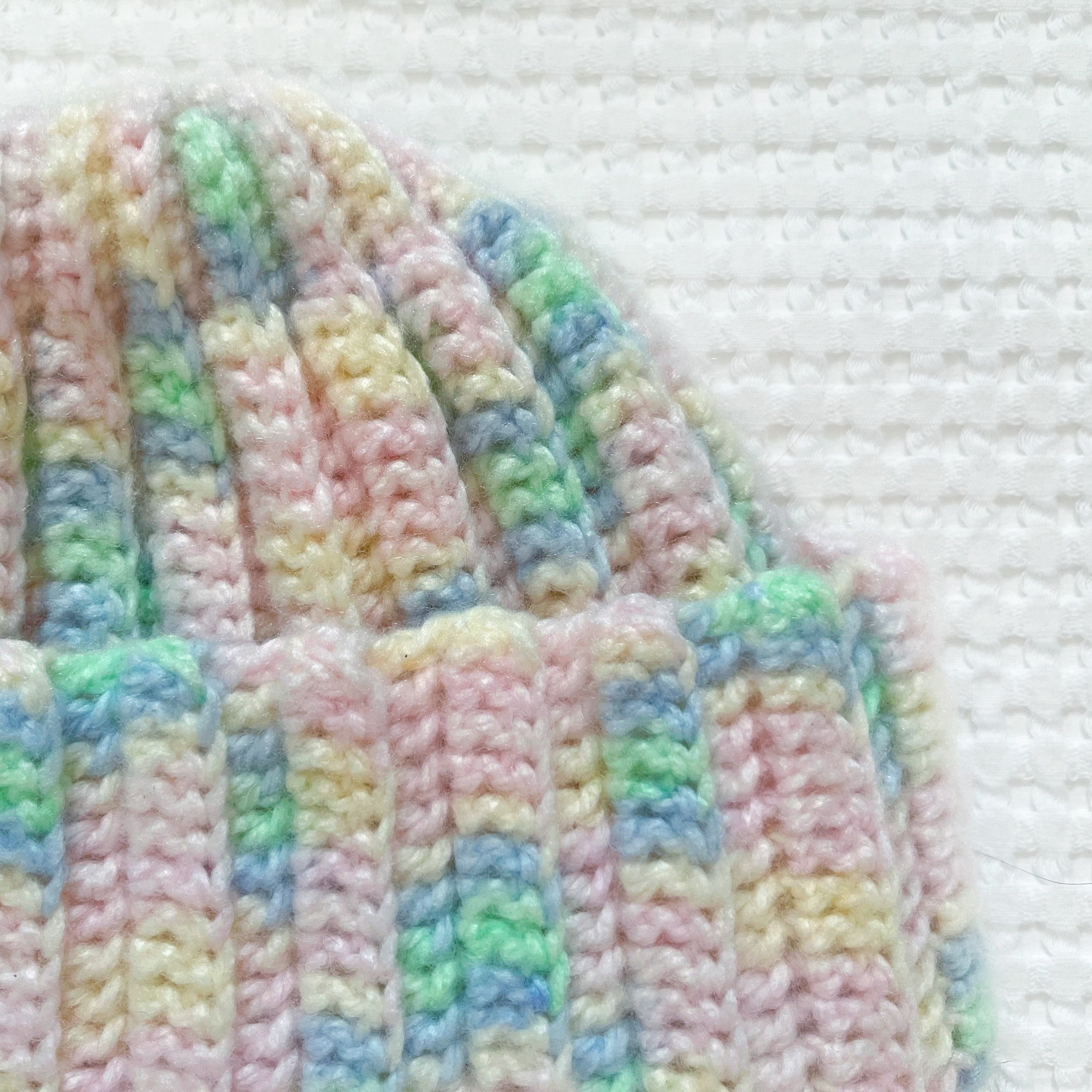 Pastel striped crochet beanie on a white background