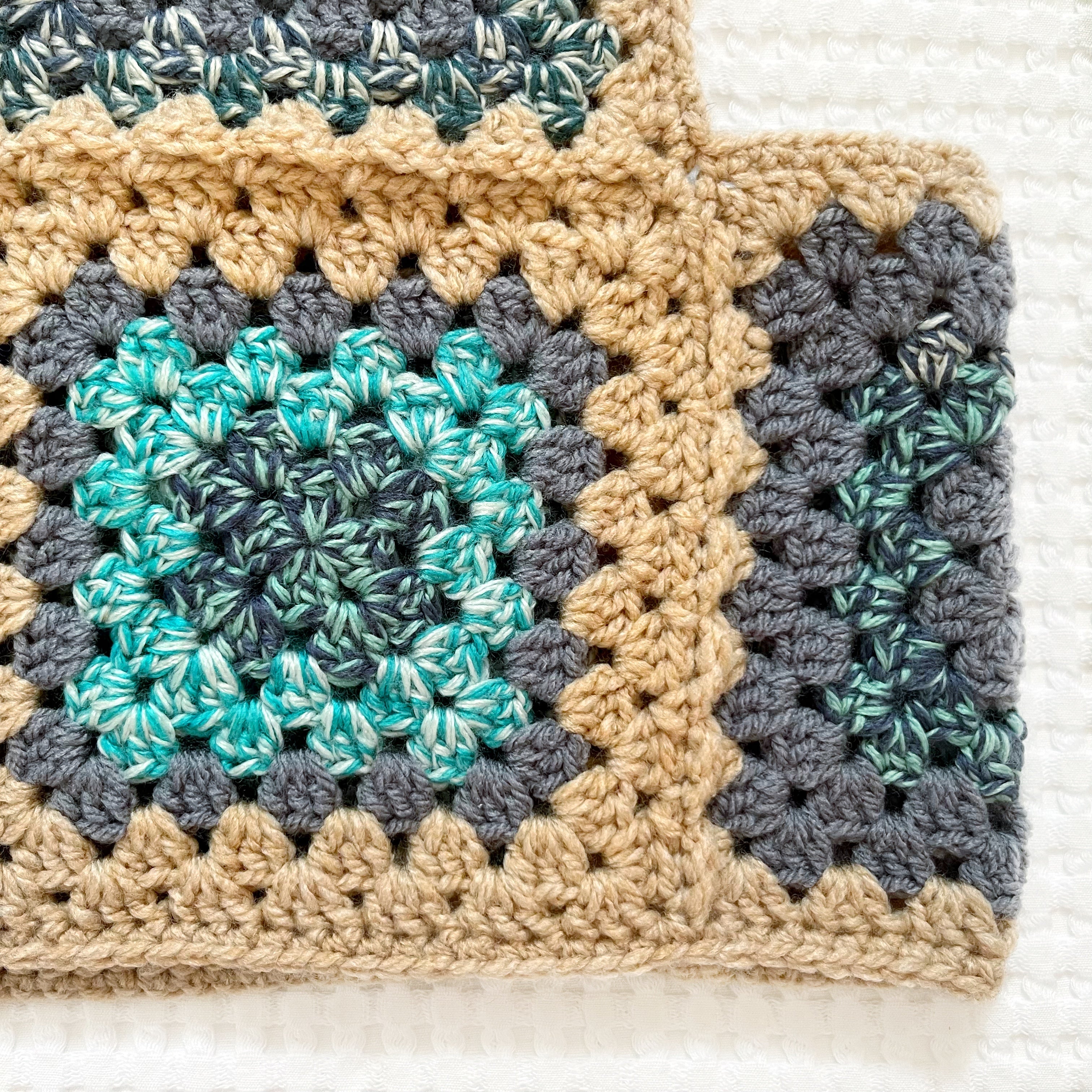 Crocheted balaclava with a square pattern on a textured white background