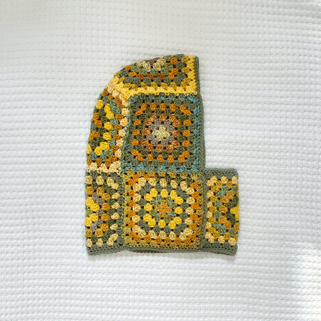 Crocheted balaclava on a textured white background