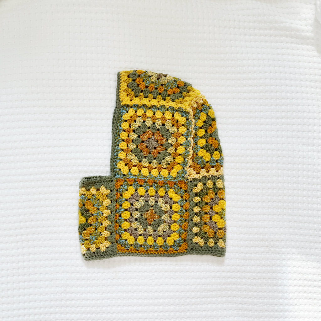 Crocheted balaclava on a textured white background